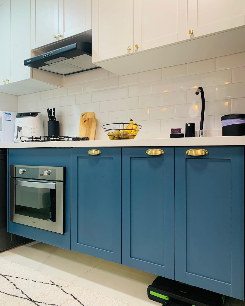 Cozinha planejada azul petróleo provençal com bancada branca e forno.