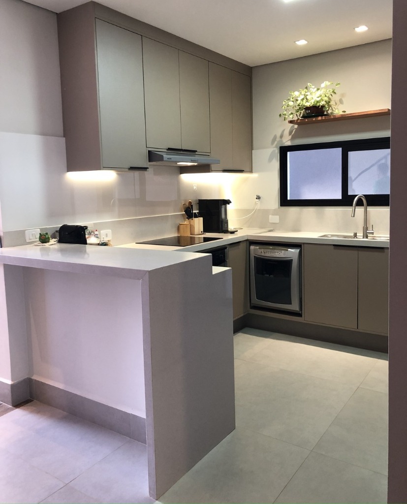 Cozinha planejada com península e bancada in quartzo cinza integrando a sala.
